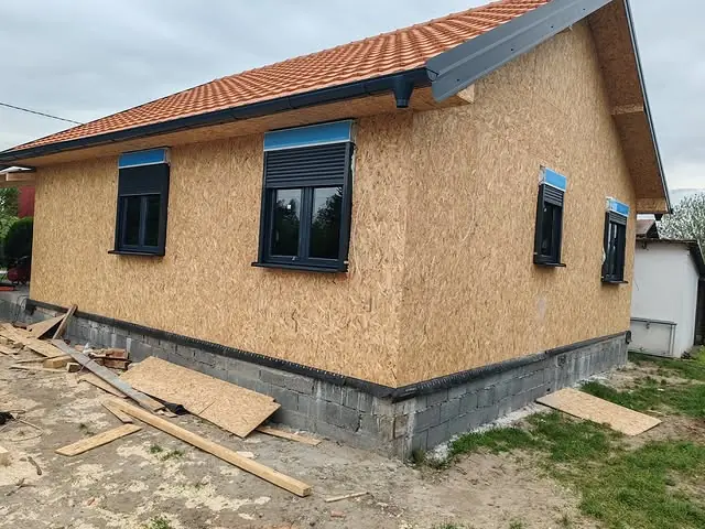 Detalj ugrađenog prozora sa spuštenom roletnom na fasadi kuće