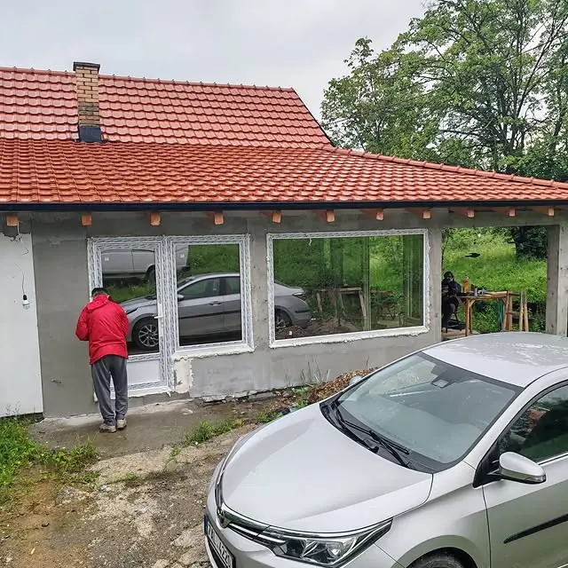 Zastakljena veranda i PVC vrata ugrađeni na porodičnoj kući sa crepnim krovom